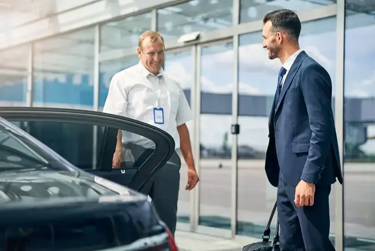 Ladybird Taxis vehicle with a professional driver assisting a passenger with luggage, ready for local and airport transfers.